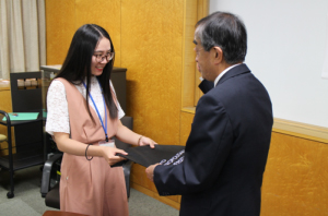 President Ueno hands gifts to students.